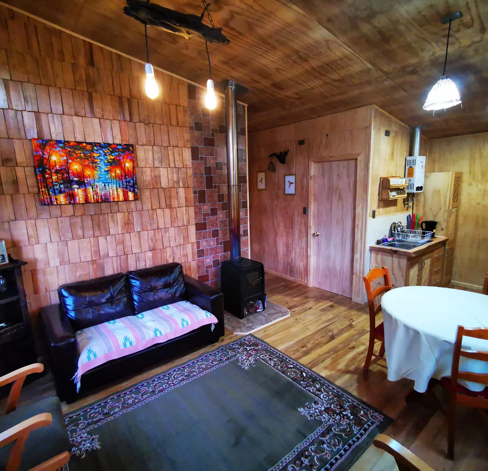 Living con cocina equipada en una cabaña de Paraíso Wilkeco