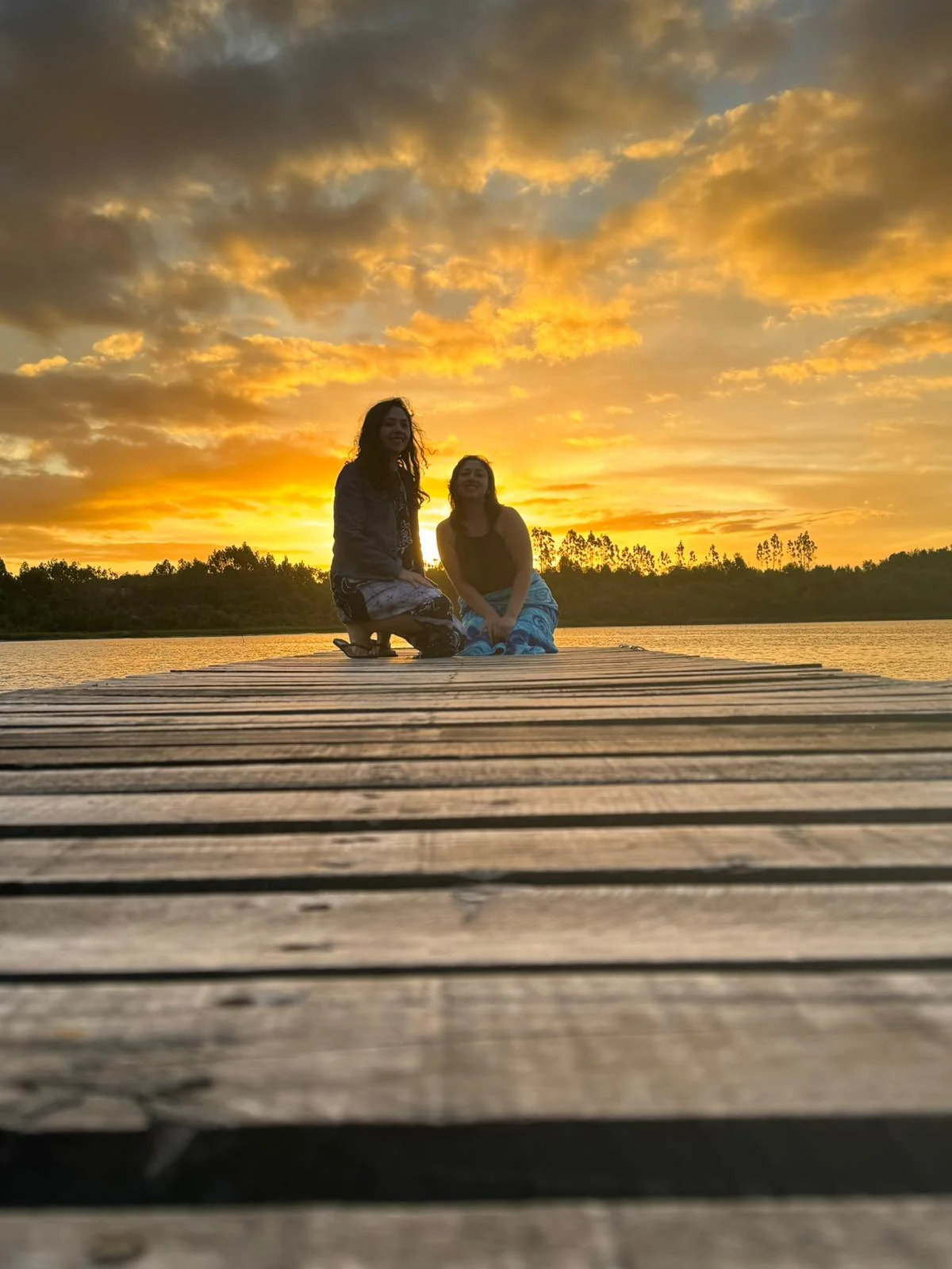 Pareja contemplando el atardecer junto al agua en Paraíso Wilkeco, Chiloé